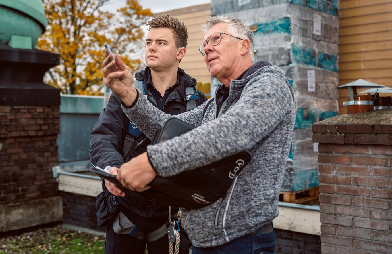 Dakinspecteur van Korff Dakwerken bespreekt de bevindingen tijdens een inspectie op het dak.
